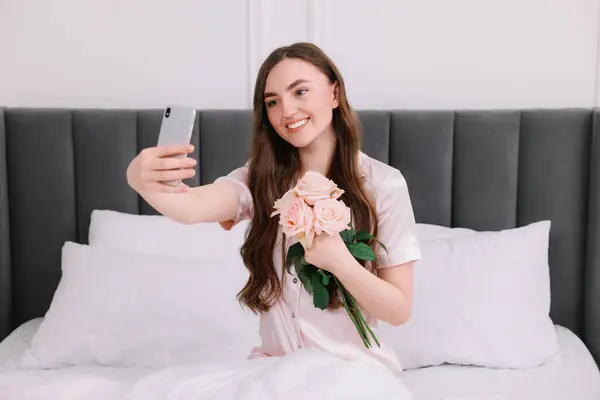 Mulher Bonita Tomando Selfie Com Flores Rosa Cama Quarto — Fotografia de Stock