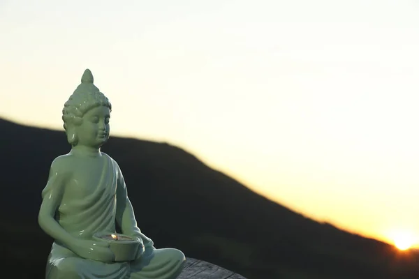 Dekoracyjny Posąg Buddy Płonącą Świecą Logu Górach Zachodzie Słońca Miejsce — Zdjęcie stockowe