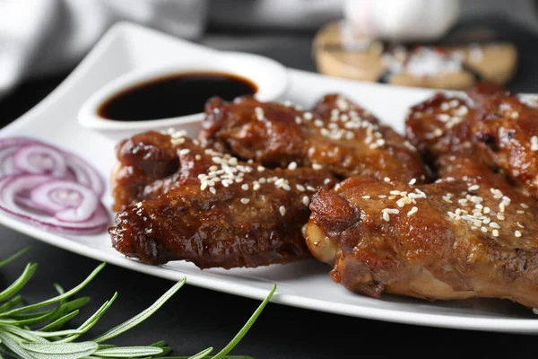 Chicken wings glazed with soy sauce served on table, closeup