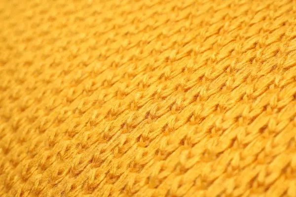 Texture of yellow knitted blanket as background, closeup