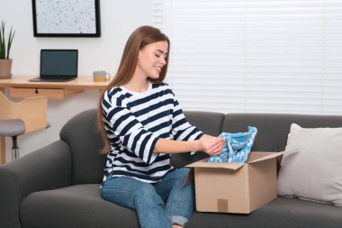 Evde paketleri açan mutlu kadın. Çevrimiçi mağaza