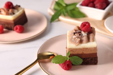 Beyaz mermer masada servis edilen ahudududulu üçlü çikolatalı kek. Metin için boşluk