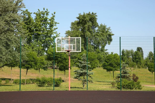 Empty basketball court outdoors on sunny day