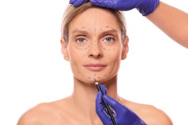 Doctor with pencil preparing patient for cosmetic surgery operation on white background, closeup clipart