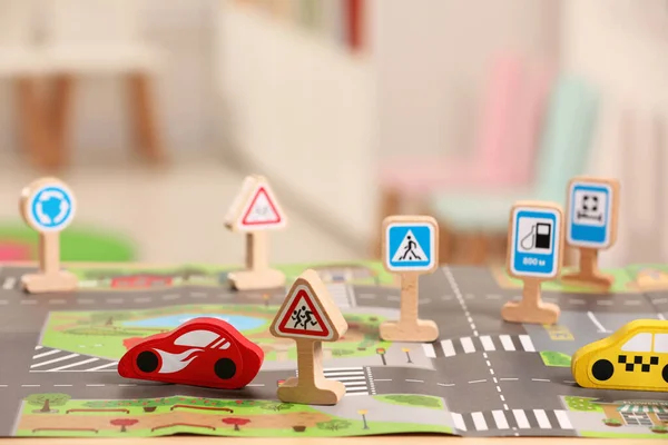 Set of wooden road signs and cars on table indoors, closeup. Children\'s toys