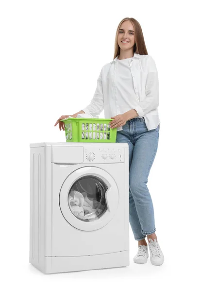 白い背景の洗濯機の近くの洗濯機のバスケットが付いている美しい若い女性 — ストック写真