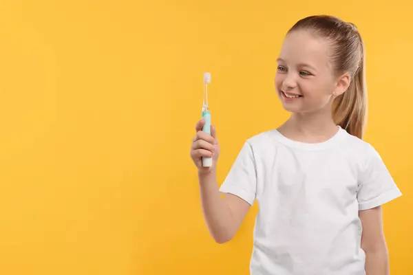 Щаслива Дівчина Тримає Електричну Зубну Щітку Жовтому Тлі Простір Тексту — стокове фото