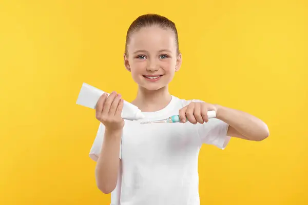 Щаслива Дівчина Стискає Зубну Пасту Трубки Електричну Зубну Щітку Жовтому — стокове фото
