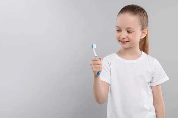 Щаслива Дівчина Тримає Зубну Щітку Світло Сірому Тлі Простір Тексту — стокове фото