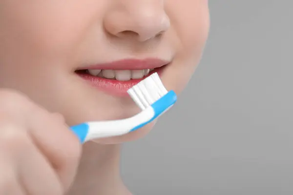 Κορίτσι Βουρτσίζει Δόντια Της Οδοντόβουρτσα Ανοιχτό Γκρι Φόντο Κοντινό Πλάνο — Φωτογραφία Αρχείου