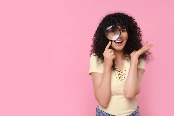 Mujer Joven Feliz Mirando Través Lupa Sobre Fondo Rosa Espacio —  Fotos de Stock
