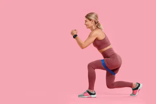 stock image Woman exercising with elastic resistance band on pink background. Space for text