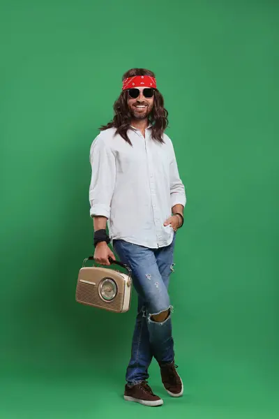 stock image Stylish hippie man in sunglasses with retro radio receiver on green background