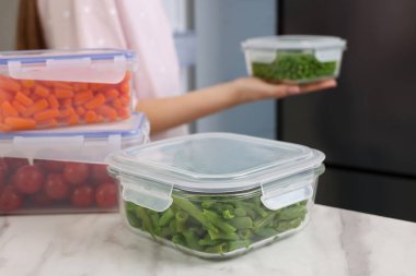 Cam ve plastik kaplar beyaz mermer masa üzerinde farklı taze ürünler, seçici odak