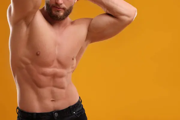 Muskulös Man Visar Abs Orange Bakgrund Närbild Och Utrymme För — Stockfoto