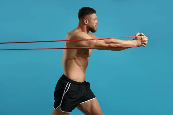 Uomo Muscolare Esercizio Con Elastico Elastico Resistenza Sfondo Azzurro — Foto Stock