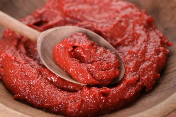 汤匙配上美味的番茄酱 放在木制碗里 — 图库照片