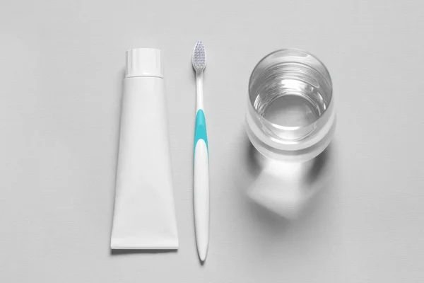 Plastic Toothbrush Paste Glass Water Grey Background Flat Lay — Stock Photo, Image
