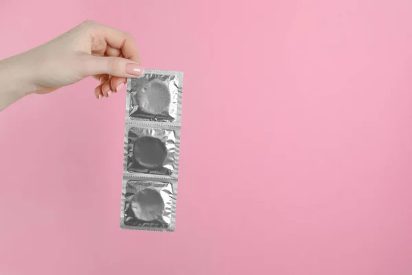 Woman Holding Condoms Pink Background Closeup Space Text — Stock Photo, Image