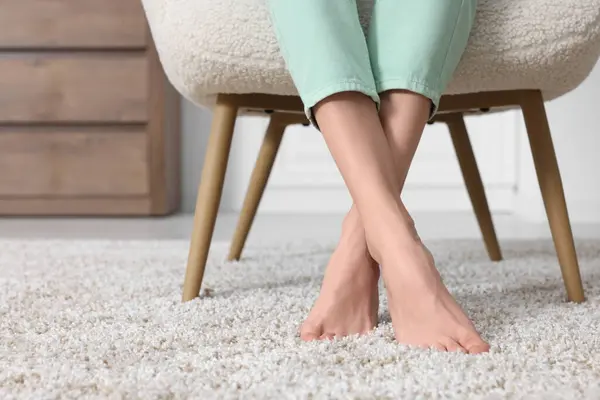 Evdeki yumuşak, açık kahverengi halıda bir kadın, yakın plan. Metin için boşluk