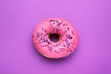 Mor arka plan üzerine serpiştirilmiş tatlı jöleli donut, üst manzara. Lezzetli şekerlemeler.