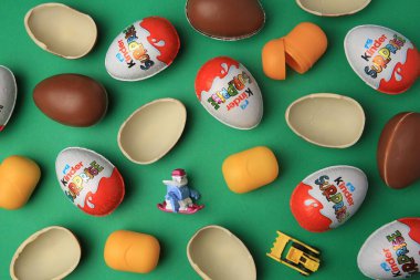 Sveti Vlas, Bulgaristan - 29 Haziran 2023: Yeşil zemin üzerinde Kinder Sürpriz Yumurtaları, plastik kapsüller ve oyuncaklar, düz zemin