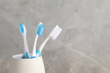 Gri arka planda plastik diş fırçaları var. Yakın plan. Metin için boşluk