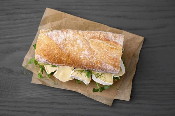 灰色の木のテーブル 上の眺めのブリーチチーズが付いているおいしいサンドイッチ — ストック写真