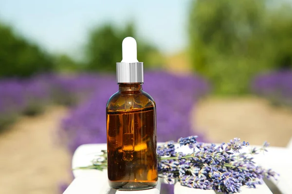 Flaska Med Eterisk Olja Och Lavendel Blommor Vitt Träbord Fält — Stockfoto