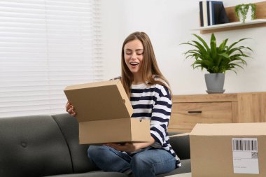 Duygusal kadın paketleri evde boşaltıyor. Çevrimiçi mağaza