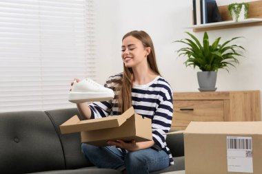 Evde paketleri açan mutlu kadın. Çevrimiçi mağaza