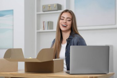 Evde paketleri açan mutlu kadın. Çevrimiçi mağaza