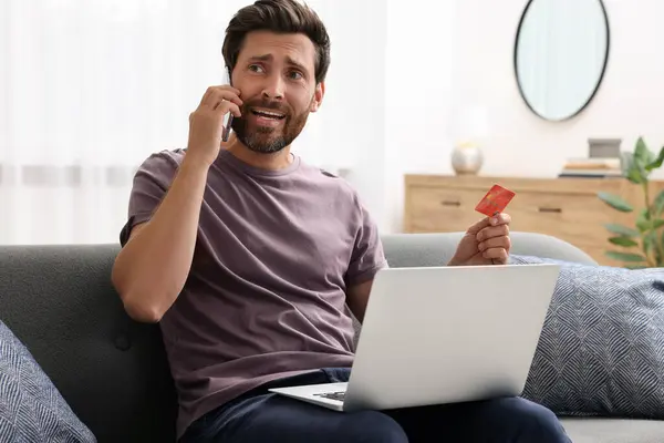 Emocjonalny Człowiek Kartą Kredytową Laptopem Rozmawiający Przez Telefon Domu Uważaj — Zdjęcie stockowe