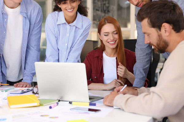 Команда сотрудников, работающих вместе за столом в офисе. Запуск проекта