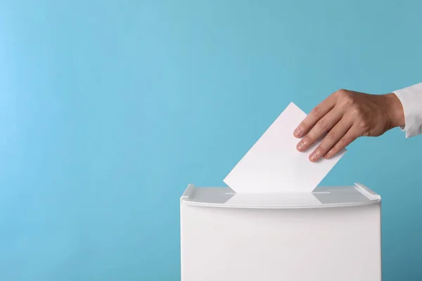 男人把他的选票放在投票箱浅蓝色背景 案文的篇幅 — 图库照片