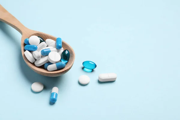 Molte Pillole Cucchiai Diversi Sfondo Azzurro Spazio Testo — Foto Stock