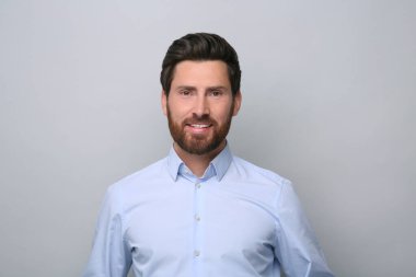 Açık gri arka planda yakışıklı bir adamın portresi