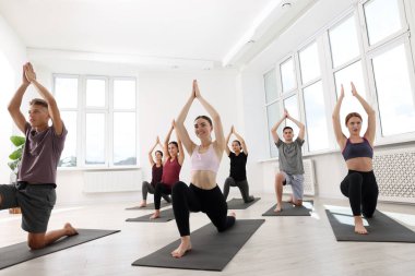 Paspaslar üzerinde yoga yapan bir grup insan, düşük açılı görüş.