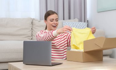 Duygusal kadın paketleri evde boşaltıyor. Çevrimiçi mağaza