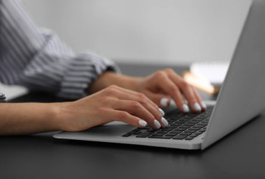 Siyah masada modern laptop kullanan kadın, yakın plan.