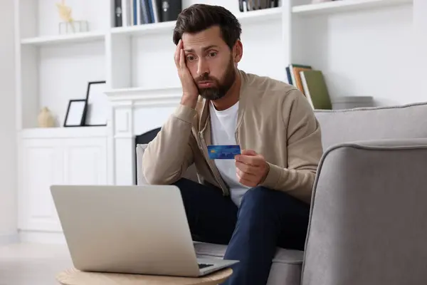 Zdenerwowany Człowiek Kartą Kredytową Pobliżu Laptopa Domu Uważaj Oszustwo — Zdjęcie stockowe