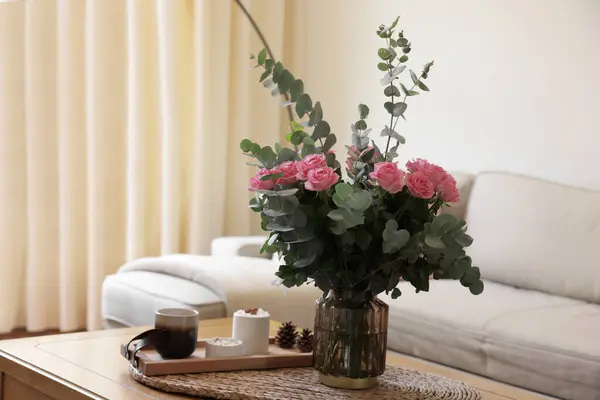 집에서 테이블에 꽃병에 장미와 유칼립투스 가지의 아름다운 꽃다발 텍스트를 — 스톡 사진