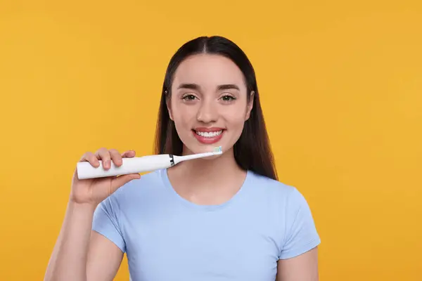 Jovem Feliz Segurando Escova Dentes Elétrica Fundo Amarelo — Fotografia de Stock