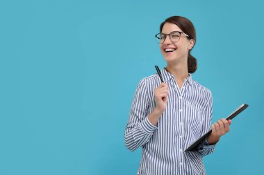 Açık mavi arkaplanda panosu ve kalemi olan mutlu sekreter, metin için boşluk