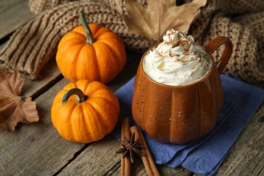 Balkabağı aromalı latte, çırpılmış krema ve ahşap masa malzemeleri.