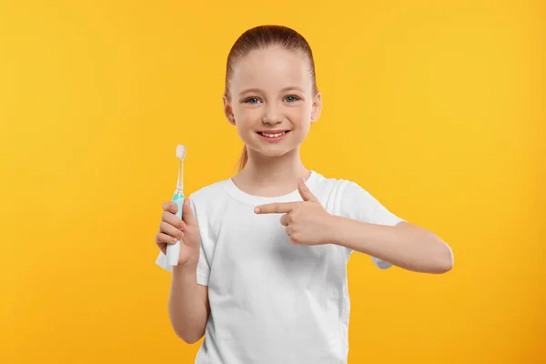 Menina Feliz Segurando Escova Dentes Elétrica Fundo Amarelo — Fotografia de Stock