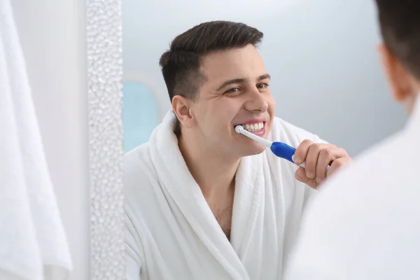 Mann Putzt Sich Badezimmer Mit Elektrischer Zahnbürste Neben Spiegel Die — Stockfoto