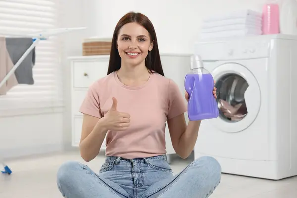 Mulher Sentada Perto Máquina Lavar Roupa Segurando Amaciador Tecido Banheiro — Fotografia de Stock