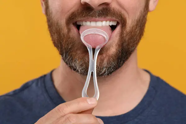 Mann Reibt Sich Die Zunge Mit Reiniger Auf Gelbem Hintergrund — Stockfoto