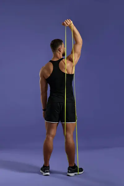 Muskulöser Mann Beim Training Mit Elastischem Widerstandsband Auf Lila Hintergrund — Stockfoto